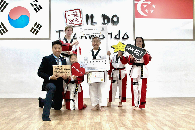  Ildo Taekwondo Academy founder and CEO Kim Jong Yoon (left) in February takes a photo with Lynn Soh (fourth from left) and other students at the academy's headquarters in Bukit Timah, Singapore, at an event marking Soh's promotion to second-degree blackbelt.