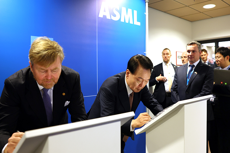 President Yoon, on a state visit to the Netherlands, on Dec. 12 signs a semiconductor wafer with Dutch King Willem-Alexander before heading to their bilateral talks during his visit to ASML headquarters in the Dutch town of Veldhoven. (Jeon Han) 
