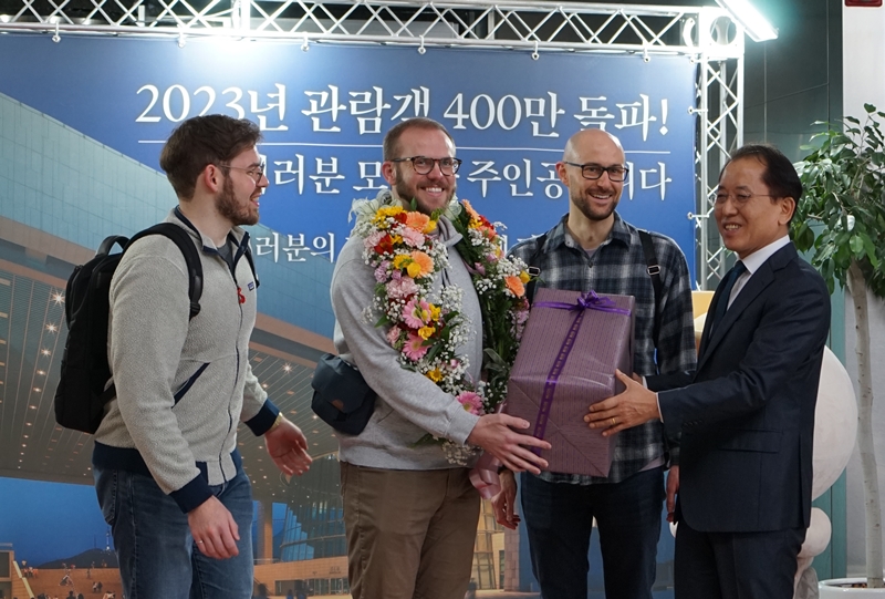 Sam Nichols (second from left) on the morning of Dec. 13 receives a gift from National Museum of Korea Director General Yoon Sung-yong for being the fourth millionth visitor to the museum in Seoul's Yongsan-gu District. 