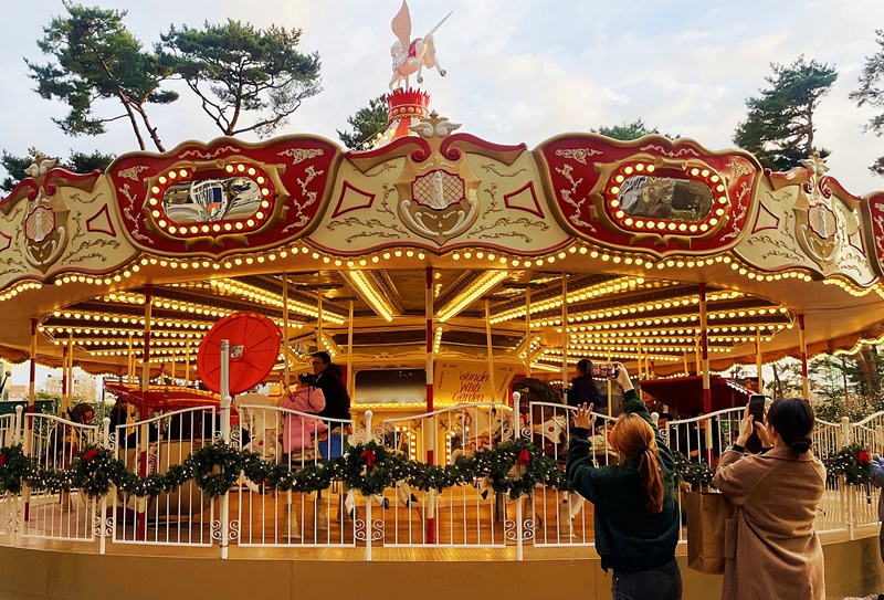 Lotte World Tower in Seoul's Songpa-gu District has the fantastic outdoor Wonder Wish Garden. After passing the maze garden gate that signals the beginning of the complex, visitors are welcomed by a large Christmas tree 19 m tall and decorated with colorful ornaments and lights with a merry-go-round behind it. (Lee Dasom) 