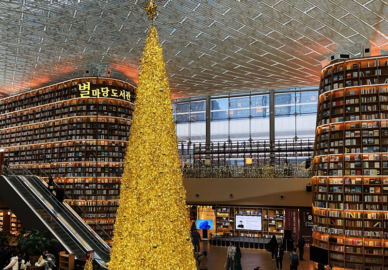 An 11 m-tall golden Christmas tree every year welcomes visitors at Starfield Library, which has over 70,000 books, at COEX Mall in Seoul's Gangnam-gu District. Media artworks are also displayed on a 13 m-high book shelf. (Lee Dasom) 