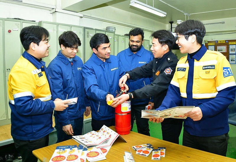 Hotels and condominiums from this year can hire foreign staff holding the E-9 (non-professional work) visa. Shown are employees of HD Hyundai Heavy Industries' safety and health support department on Dec. 28 distributing leaflets on fire safety published in 16 languages to its foreign workers. (HD Hyundai Heavy Industries) 