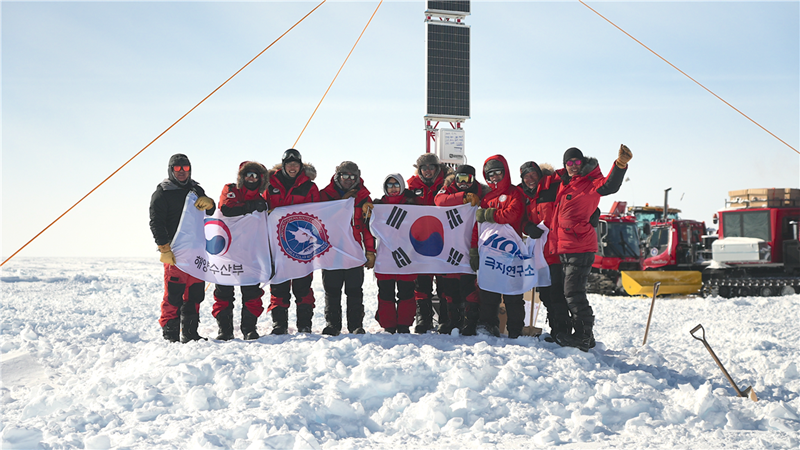 A scientific exploration team has arrived at a candidate site for a new Antarctic inland research base, securing a crucial inland route for research and material supply in and around the South Pole. Shown is the team on Dec. 31 posing for photos after arriving at the site. (Korea Polar Research Institute​) 