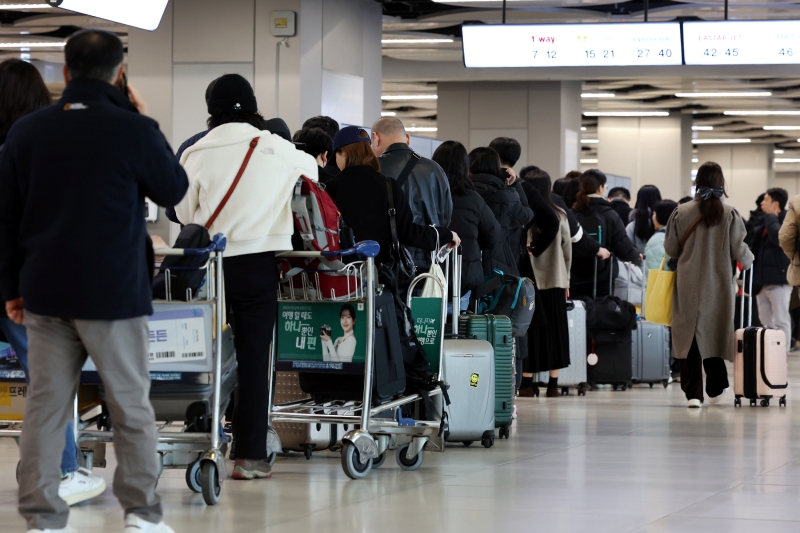 The number of domestic and international air travelers last year exceeded 100 million for the first time in four years. Seen are passengers on Dec. 29, 2023, lining up to check in for a domestic flight at Gimpo International Airport. (Yonhap News)