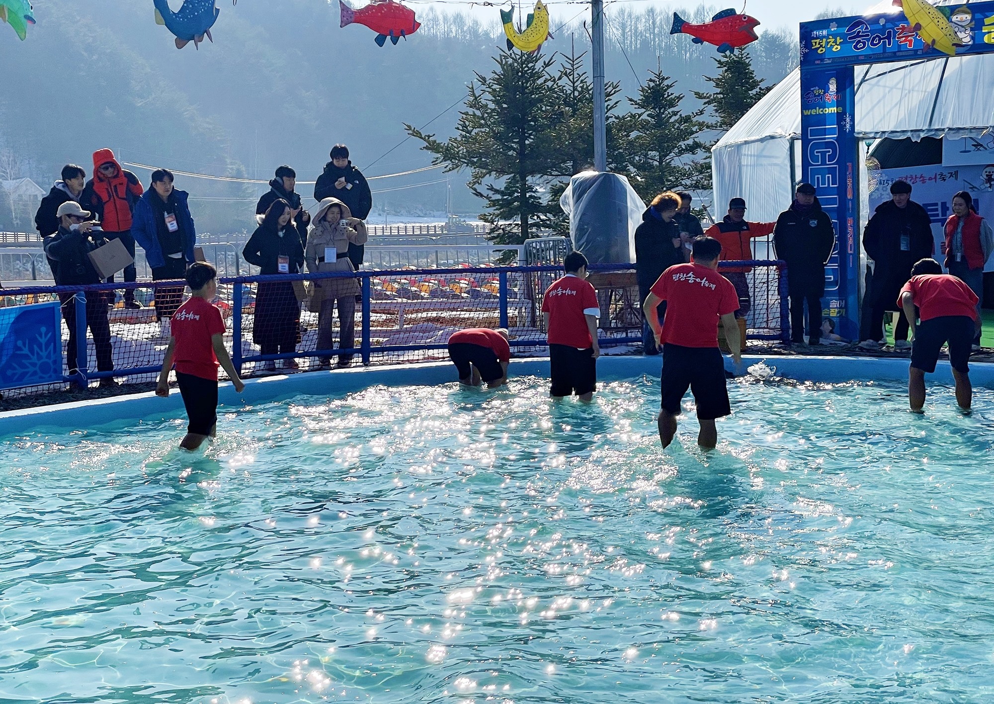 The Pyeongchang Trout Festival through Jan. 28 runs by Odaecheon Stream in Pyeongchang-gun County, Gangwon-do Province, in conjunction with Gangwon 2024. Shown are tourists trying bare-handed trout fishing.