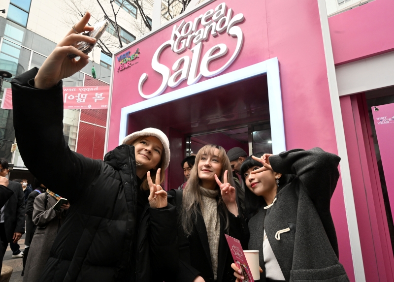 Foreign tourists on Jan. 11 take a photo in front of Myeongdong Welcome Center in Seoul's Jung-gu District during the opening of this year's Korea Grand Sale. (Yonhap News) 