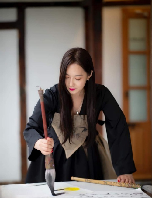 Kim So-young uses a big brush on one of her works.