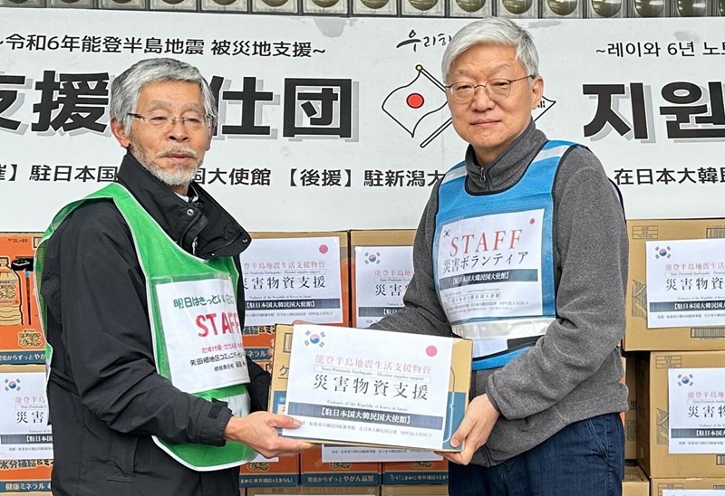 Ambassador to Japan Yun Duk-min (right) on Feb. 20 gives relief aid at Yatago Community Center in Nanao, Ishikawa Prefecture