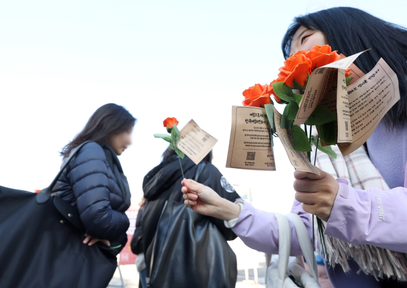 To mark International Women's Day, a member of the non-profit activist organization Korea Women's Hot Line on March 8 gives roses to students at Ewha Womans University in Seoul's Seodaemun-gu District. The group that day distributed roses to about 5,000 women in Seoul.