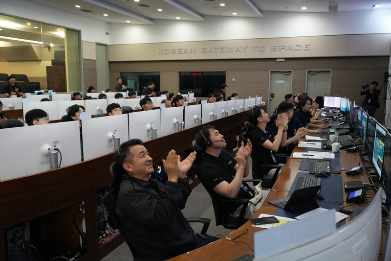 Staff at the ground station in Daejeon of the Korean Aerospace Research Institute on April 24 celebrate after NEONSAT-1 establishes two-way communication with the station after being launched into space.