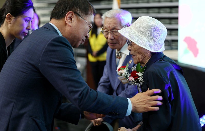  Acting First Vice Seoul Mayor for Administrative Affairs Kim Sanghan (left) on May 8 pins carnations on Park Tae-nam, 96, and Kim Ok-rye, 93, at a Parents' Day ceremony hosted by the city government at Jangchung Gymnasium in Seoul's Jung-gu District.