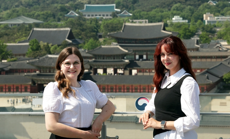 Anne Sophie Schroeder (left) from Germany and Sarah Shalaby from France, two volunteers at this year's spring K-Royal Culture Festival, take a photo on May 10 with Gyeongbokgung Palace in the background in Seoul's Jongno-gu District. (Jeon Han)