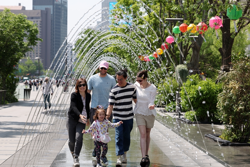 A French tourist group on May 10 walks under a water fountain tunnel at Gwanghwamun Square in Seoul's Jongno-gu District. Korea last year was ranked 14th by the Travel and Tourism Development Index of the World Economic Forum. (Jeon Han)