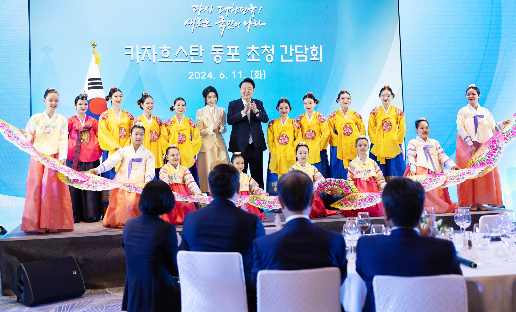 President Yoon Suk Yeol (seventh from left on stage's second row) and first lady Kim Keon Hee on June 11 pose for photos with members of an ethnic Korean dance troupe at a meeting with Goryeoin, or ethnic Koreans in Central Asia, at a hotel in Astana, Kazakhstan. (Yonhap News) 
