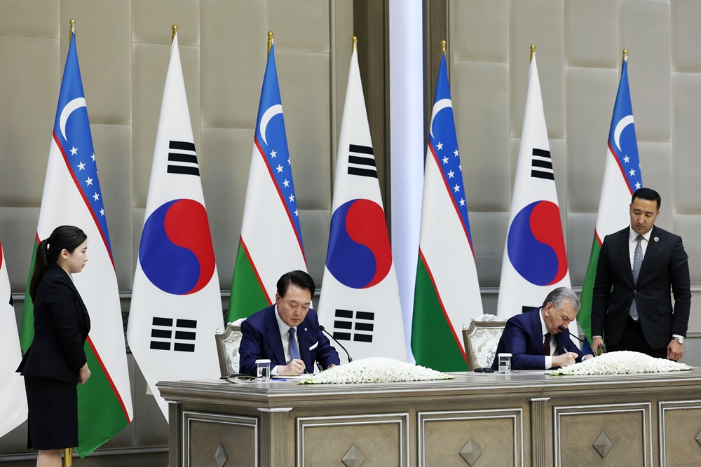 President Yoon Suk Yeol (left) and Uzbek President Shavkat Mirziyoyev on June 14 sign a joint statement on deepening and comprehensively expanding the special strategic partnership between the two nations at the presidential palace in the Uzbek capital of Tashkent. (Jeon Han)