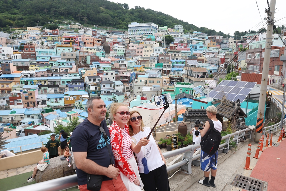 A policy coordination meeting chaired by Prime Minister Han Duck-soo on June 20 at Government Complex-Sejong announced measures to improve the management of foreign workers. Shown are tourists on June 17 posing for photos at Gamcheon Culture Village in Busan's Saha-gu District. (Ministry of Culture, Sports and Tourism) 