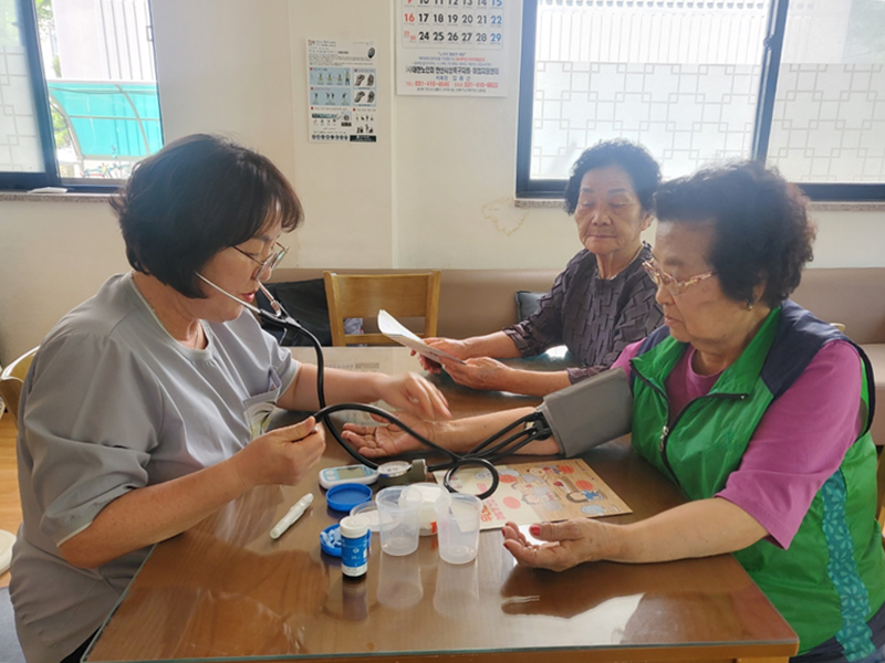 The city of Ansan, Gyeonggi-do Province, runs a support group for preparation for a heat wave with professionals like visiting nurses to help the underprivileged such as senior citizens who live alone or welfare receipients. Shown are two eldelry women receiving treatment for heat-related ailments. (Ansan City Hall)