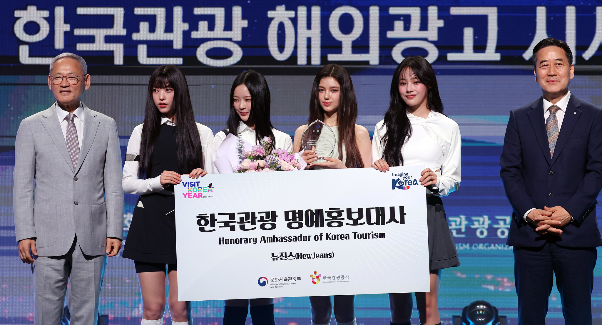 Minister of Culture, Sports and Tourism Yu In Chon (left) on July 11 at the Grand Hyatt Seoul poses for photos with the K-pop girl group NewJeans -- (from second from left) Haerin, Hanni, Danielle and Minji -- and acting Korea Tourism Organization President Seo Young-choong (far right) at the ceremony for the group's appointment as honorary tourism ambassador. .