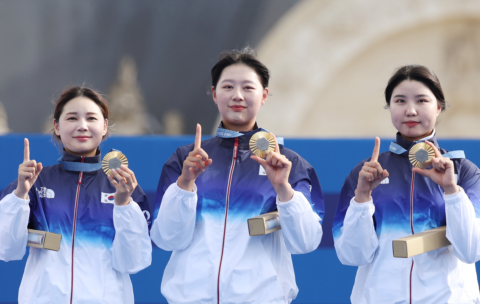 Members of the national women's archery team (from left) -- Jeon Hunyoung, Lim Sihyeon and Nam Suhyeon -- on July 28 make the number 10 with their fingers at the Paris Summer Olympics' awards ceremony after clinching Korea's 10th straight title in the event at Les Invalides in the French capital. 