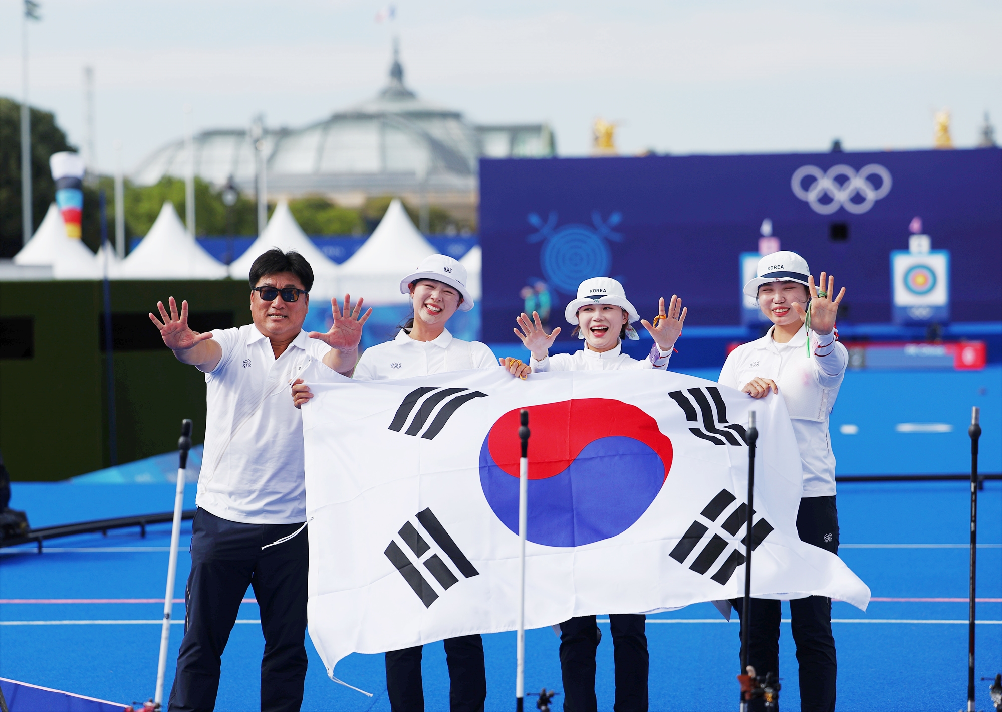 The national women's archery squad -- (from left) head coach Yang Chang-hoon and players Lim Sihyeon, Jeon Hunyoung and Nam Suhyeon -- holds the national flag Taegeukgi after claiming the team gold at Les Invalides in the Paris Summer Olympics. 