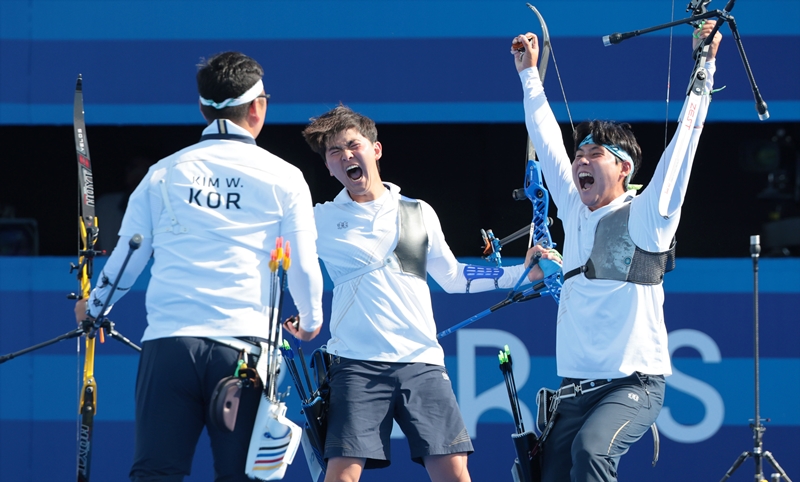 The national men's archery team -- (from left) Kim Woojin, Kim Je Deok and Lee Wooseok -- on July 29 cheers after winning its third straight Olympic title at the Paris Summer Olympics after beating France in the finals at Les Invalides in the French capital.