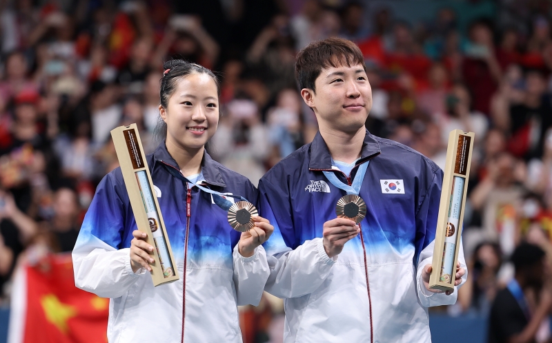 Table tennis stars Shin Yubin (left) and Lim Jonghoon on July 30 greet the crowd at South Paris Arena 4 after winning the bronze medal in mixed doubles at the Paris Summer Olympics. 