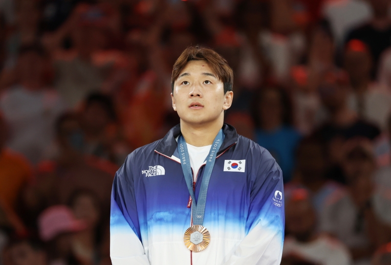 Judoka Lee Joonhwan on July 30 at the Champ-de-Mars Arena in Paris stands at the medals ceremony after winning the bronze in the men's 81-kg class.  