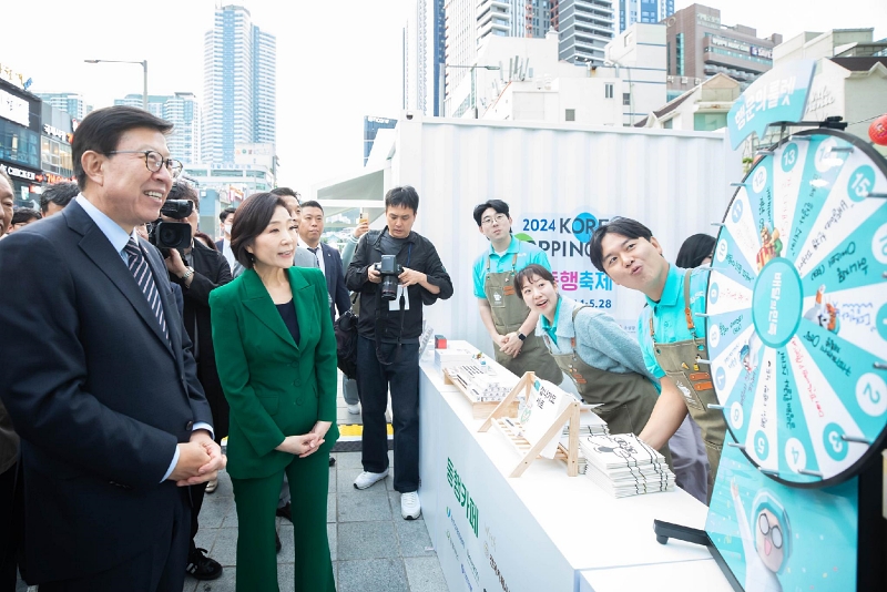 Minister of SMEs and Startups Oh Youngju (second from left) and Busan Mayor Park Heong-joon (left) in May talk with merchants at the opening ceremony of K-Shopping Festa at Guam-ro Culture Square in Busan's Haeundae-gu 