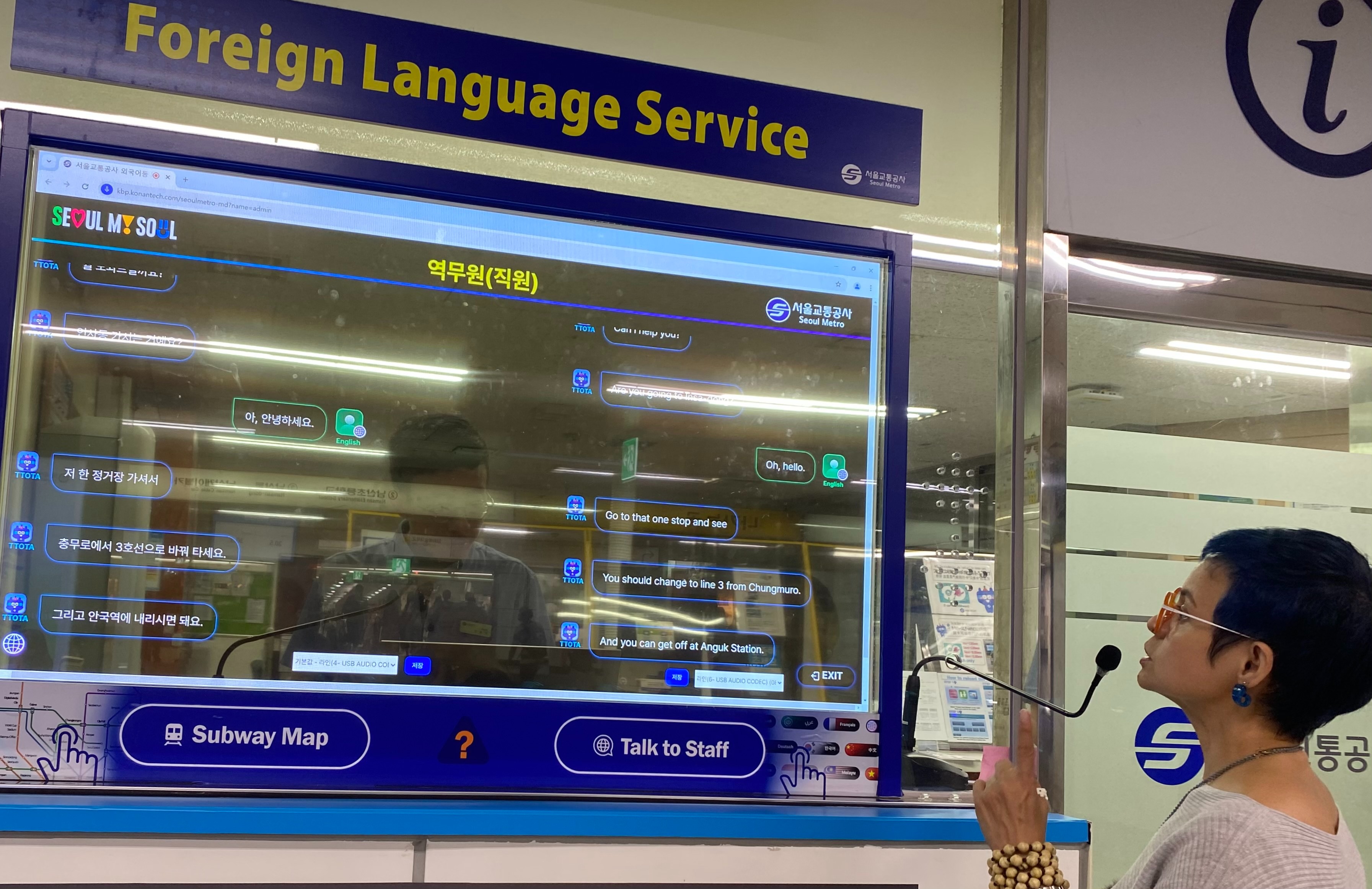 Honorary Reporter Mae Young on Aug. 22 uses the artificial intelligence-based simultaneous interpretation service at Myeongdong Station. Once a staff member and a rider speak, the system automatically shows the translated text on a transparent screen dividing the subway office and users. The service is offered in 13 languages at 11 subway stations in Seoul frequented by many foreign tourists including Gwanghwamun, Hongik University and Gimpo International Airport stations. (Mae Youn