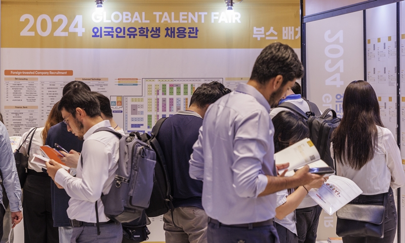 The order of foreign names in all administrative documents will be unified. Shown are foreign students in Korea on Aug. 27 perusing job ads at this year's Global Talent Fair at COEX Mall in Seoul's Gangnam-gu District. (Yonhap News)
