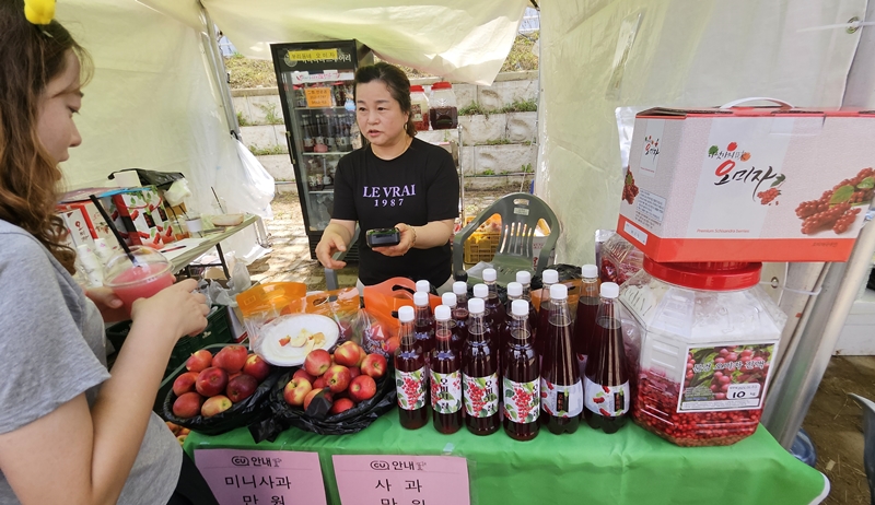 A visitor buys omija slush at a sales booth for food products containing the berry such as cheong (marmalade), makgeolli (milky rice wine) and ade.