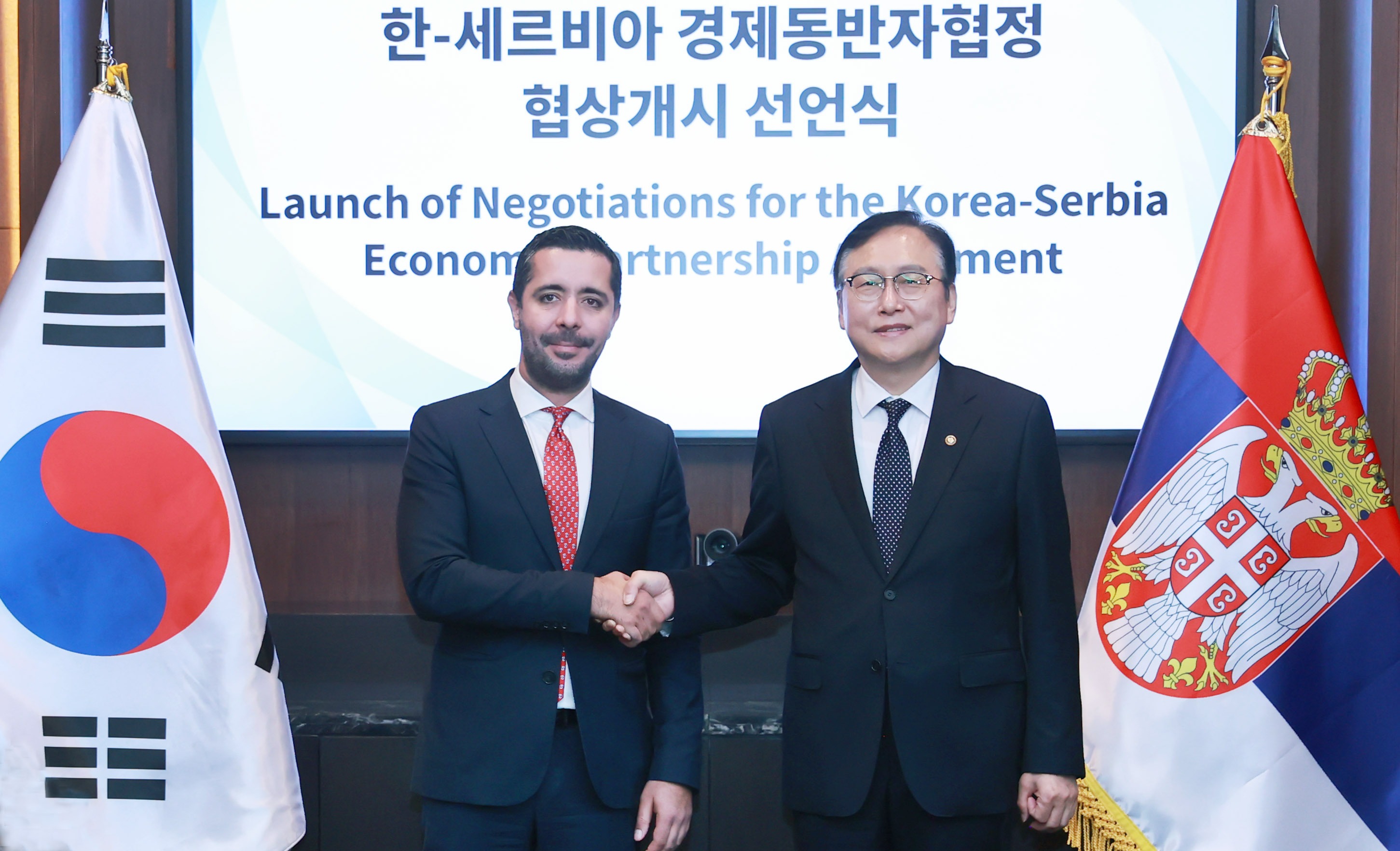Minister for Trade Cheong Inkyo (right) on Sept. 26 poses for photos with Serbian Minister of Domestic and Foreign Trade Tomislav Momirovic at a declaration ceremony for the launch of talks on a bilateral economic partnership agreement at the hotel Conrad Seoul in Seoul's Yeongdeungpo-du District. (Ministry of Trade, Industry and Energy)  