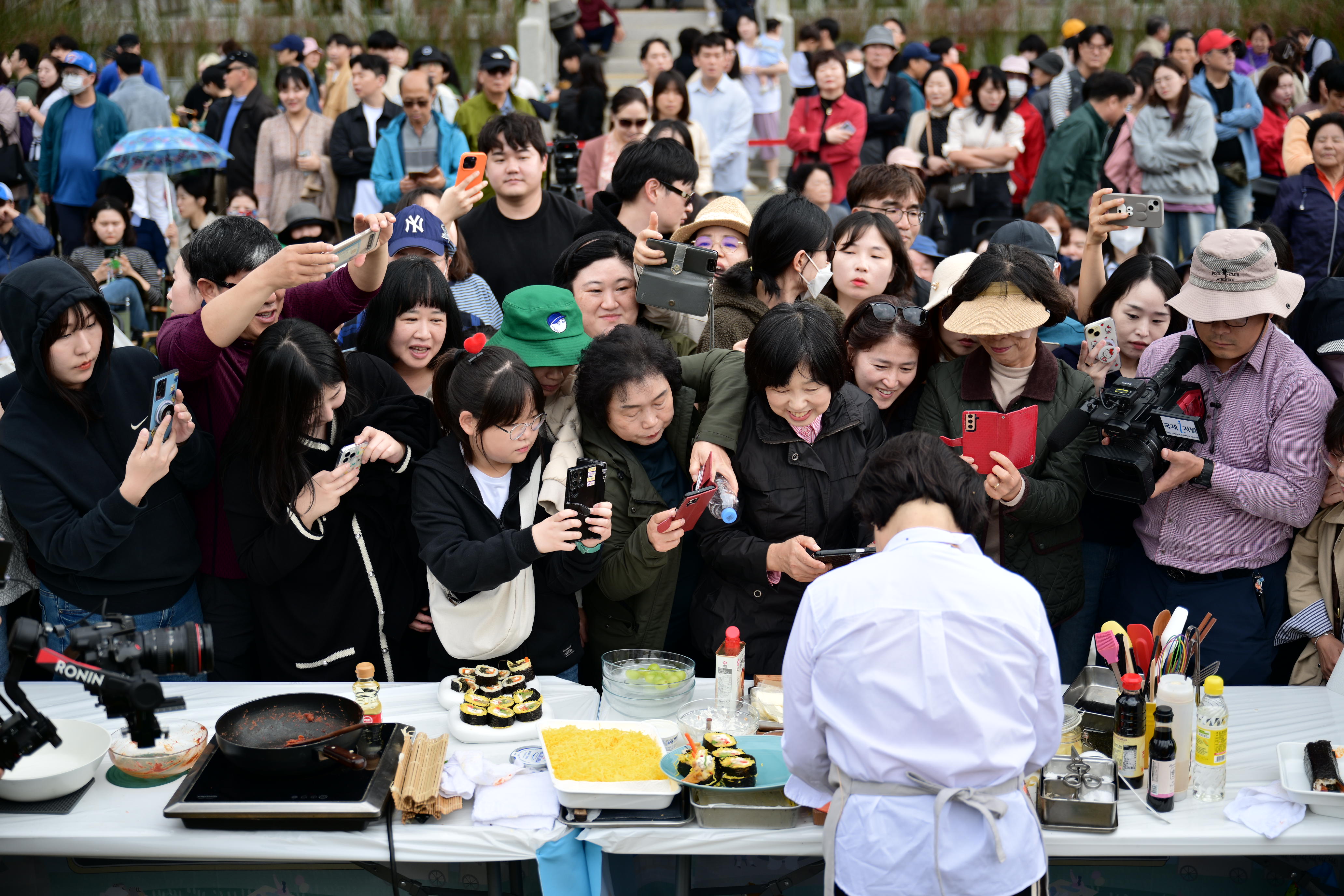 Visitors to the Gimcheon Gimbap Festival on Oct. 26 take photos of culinary researcher Lee Hye-jung preparing gimbap. (Festival's secretariat)
