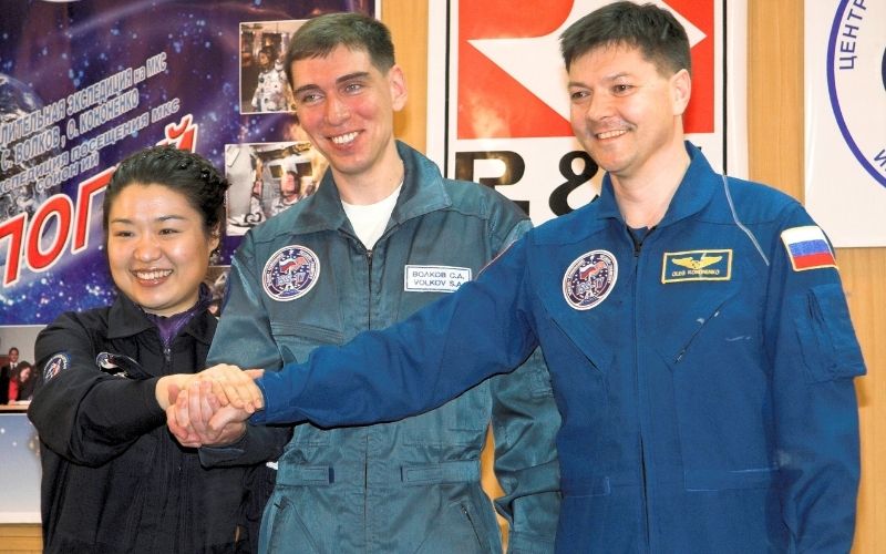Soyuz TMA-12 Crew, at their crew quarters in Baikonur, Kazakhstan, Expedition 17 Commander Sergei Volkov (center), Flight Engineer Oleg Kononenko (right) and Soyeon Yi (left) clasp hands for photographers on April 7, 2008, the eve of their launch to the International Space Station (photo by NASA/Victor Zelentsov, public domain, via Wikimedia Commons)