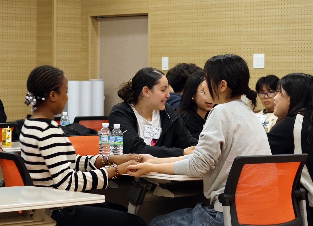 French student Wiam (middle) talks with classmates in a Hangeul (Korean alphabet) class while visiting Sanjeong Middle School in Gwangju.