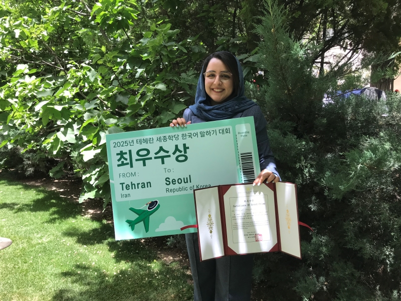 The winner of this year’s contest poses with her certificate and ticket to Seoul for the final round, which will take place in Korea around October. 