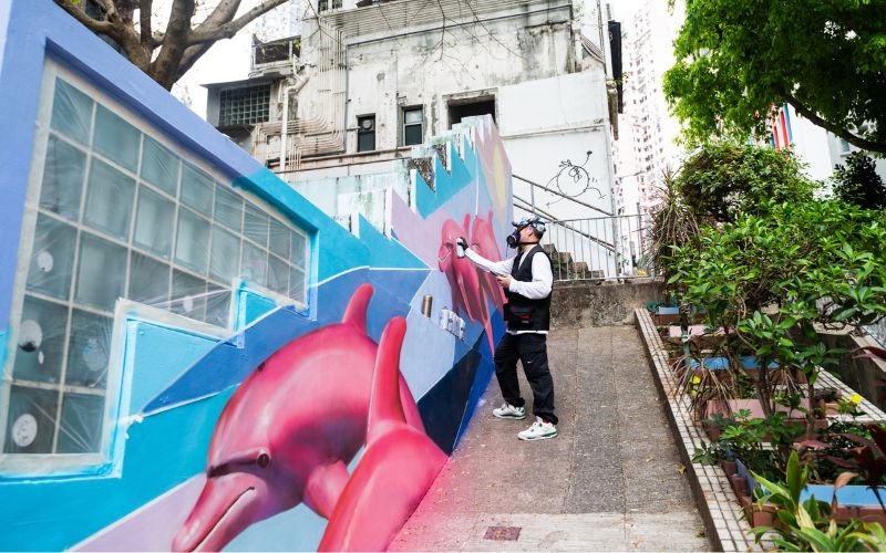 Yoo paints dolphins leaping through the waves, symbolizing joy and intelligence, on 26 Square Street in Sheung Wan, Hong Kong. 