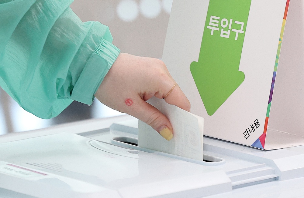 A voter on May 29, the first day of early voting for the June 3 presidential election, inserts a ballot at a polling station inside an administrative welfare center in the town of Yuga-eup in Daegu's Dalseong-gun County. (Yonhap News)  