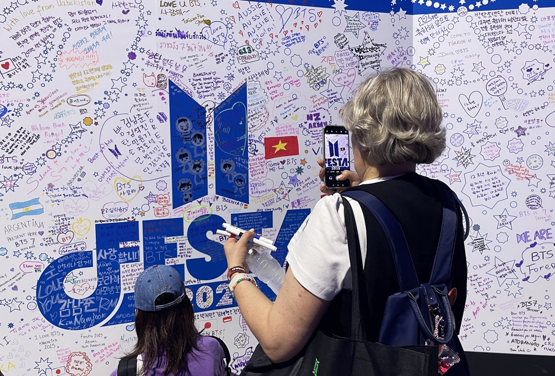 BTS fans from all over the world on June 13 gather for the 2025 BTS Festa, which marks the 12th anniversary of the group's debut, at Halls 9 and 10 of Exhibition Center 2 at the Korea International Exhibition Center, aka KINTEX, in Goyang, Gyeonggi-do Province. (Xu Aiying) 