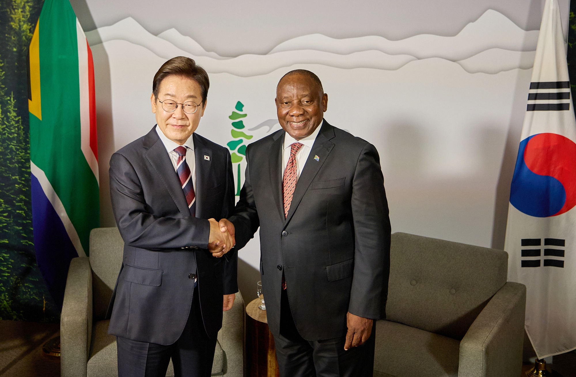 President Lee Jae-myung (left) on June 16 shakes hands with South African President Cyril Ramaphosa at a hotel in Calgary, Canada, on the sidelines of the G7 Summit. 