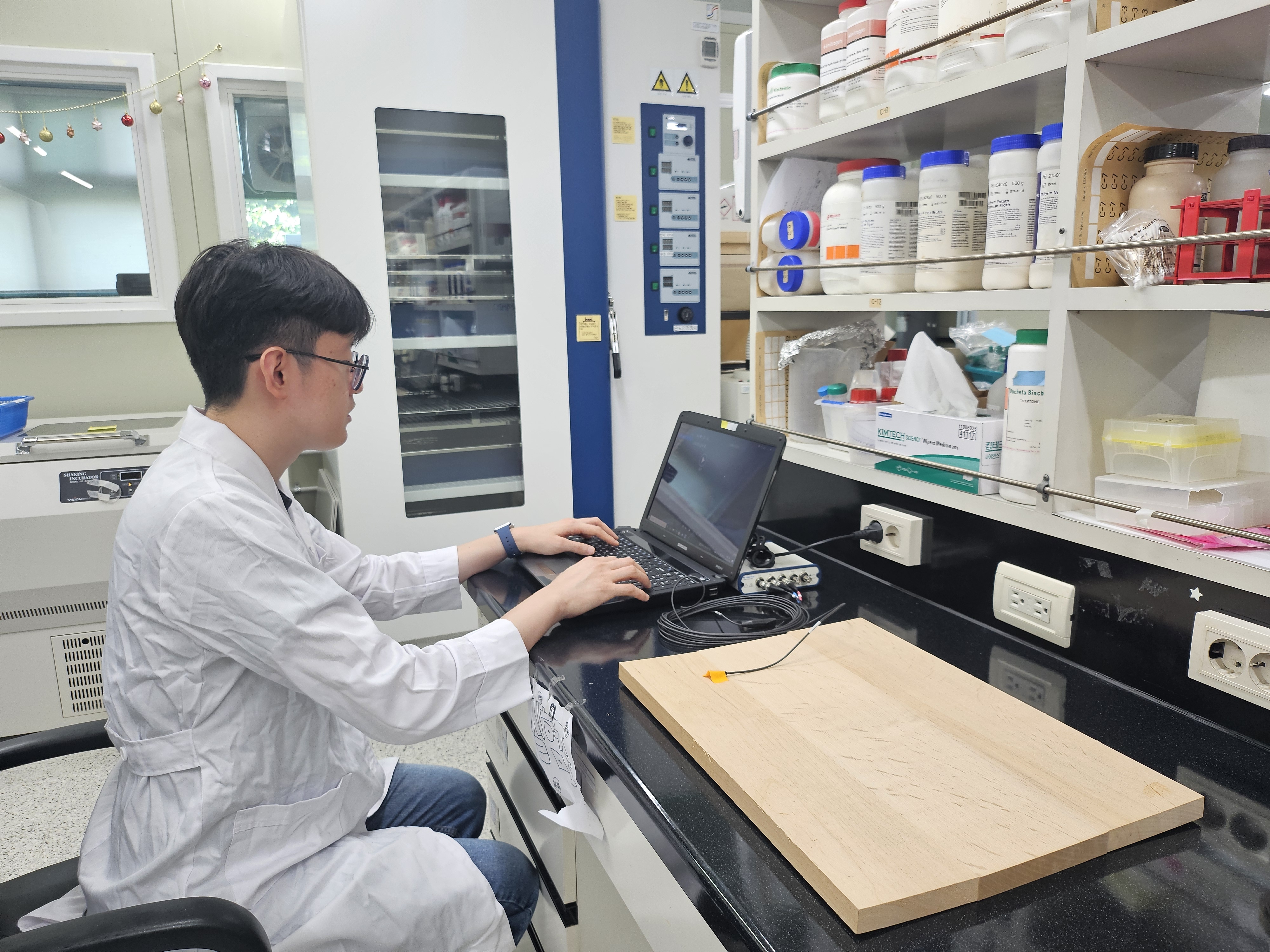 A researcher at the National Institute of Forest Science examines at the acoustic properties of wood using microorganisms. (National Institute of Forest Science)