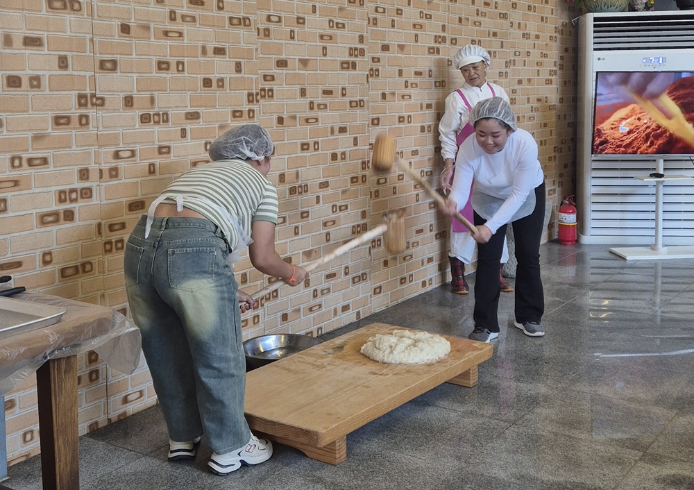 Seasonal workers from Laos on July 14 make injeolmi, or rice cake coated in soybean powder. (Sunchang-gun Office)