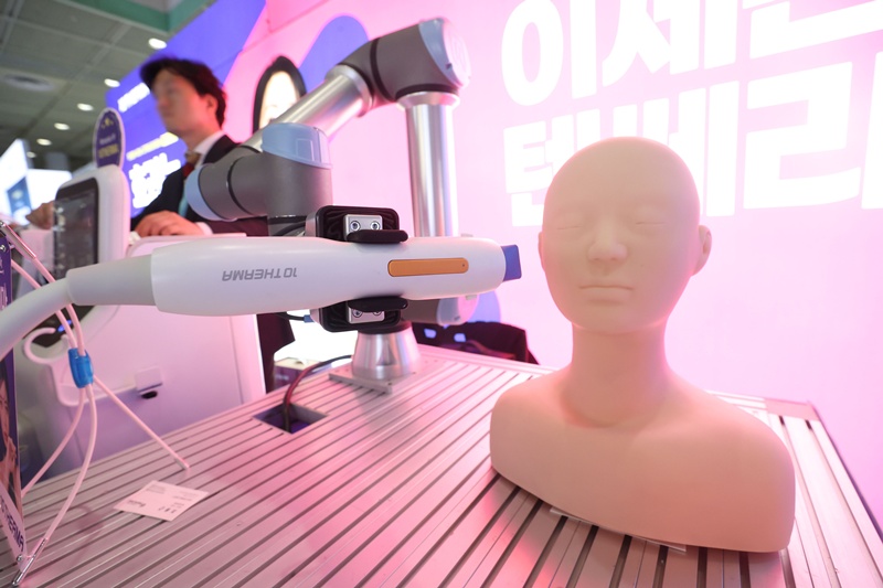 A robot demonstrates a face-lifting treatment in May last year at the 2024 Korean Association for Laser Dermatology and Trichology Academic Symposium and Aesthetic Medicine Device Exposition at COEX Mall in Seoul's Gangnam-gu District. (Yonhap News)  