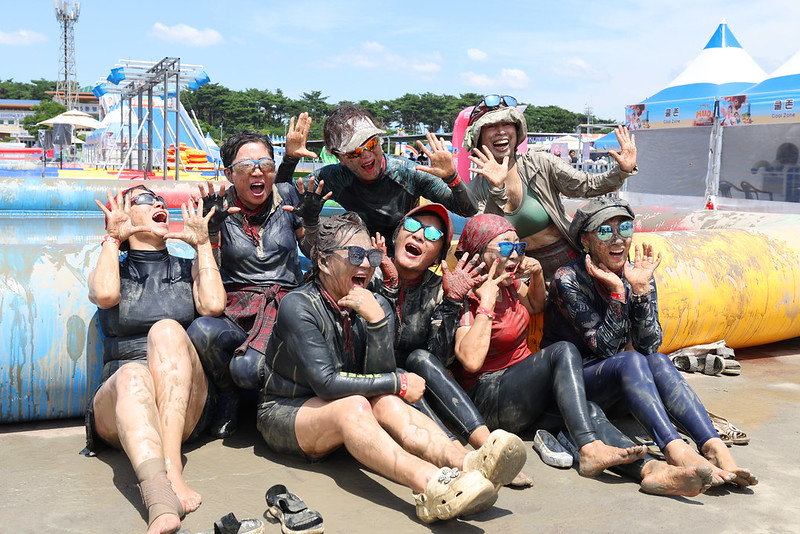Beachgoers at Daecheon Beach in Boryeong, Chungcheongnam-do Province, raise their hands and shout in excitement at the Boryeong Mud Festival.  