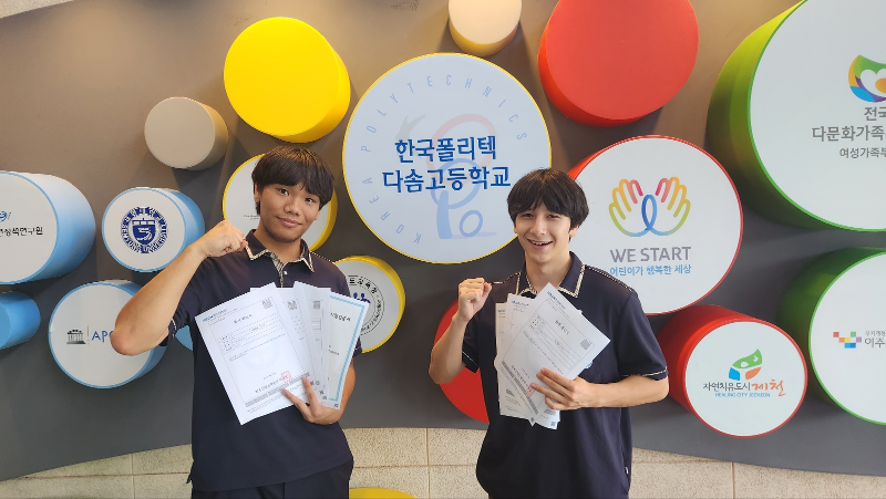 Over 60% of youth from muilticultural families attend college, a survey says. Shown are two students from such families at Korea Polytechnic Dasom High School in Jecheon, Chungcheongbuk-do Province, posing for a photo while showing their national technical certifications. (Ministry of Employment and Labor) 