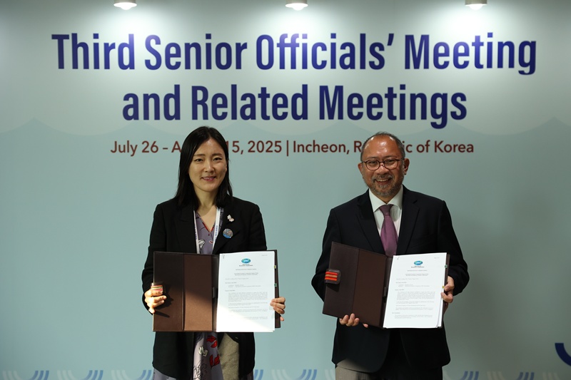 Lee Jiyoon (left), deputy director-general of the Ministry of Foreign Affairs' International Economic Affairs Bureau, on Aug. 11 poses with Eduardo Pedrosa, executive director of the Asia-Pacific Economic Cooperation (APEC) Secretariat, while holding up the two copies of a memorandum of understanding on the launch of the APEC Sub-Fund on Prosperity of Future Generations at the APEC Senior Officials Meeting in Incheon. (Ministry of Foreign Affairs)  