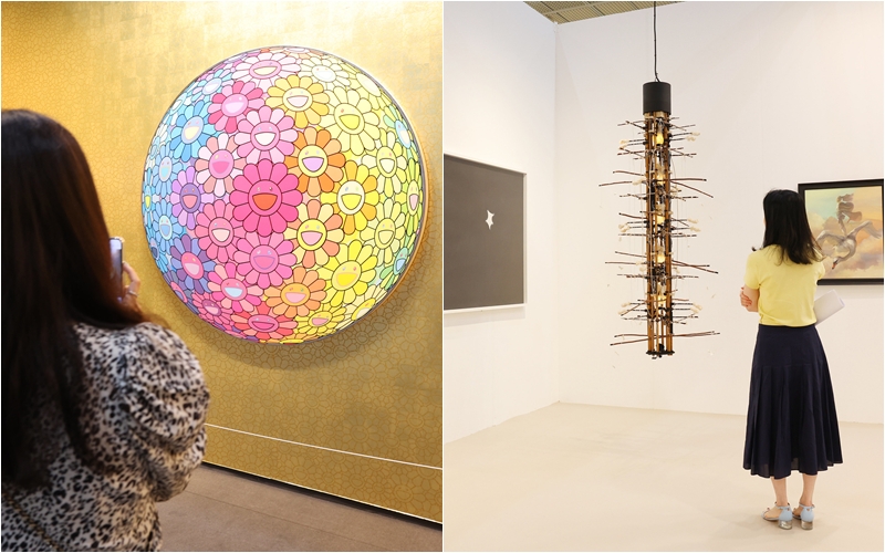 Visitors to KIAF Seoul and Frieze Seoul on Sept. 3 look at works there. On the left are the works of Takashi Murakami from Perrotin Gallery and on the right are those of Yang Jung Uk from Gallery Hyundai. (Lee Jeongwoo)