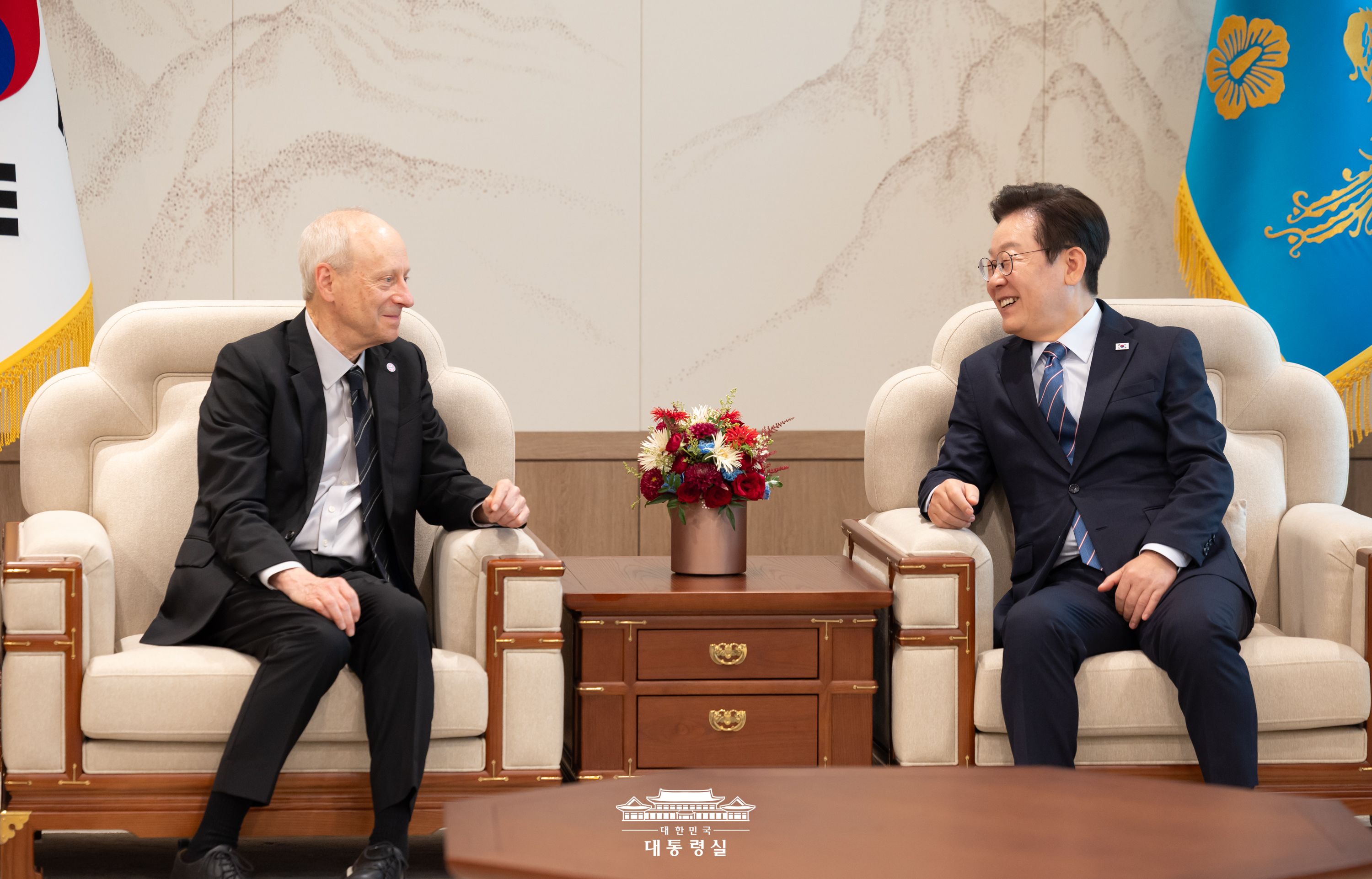 President Lee Jae Myung (right) on Sept. 18 speaks to Michael Sandel (left), an American political philosopher and author of the bestseller 