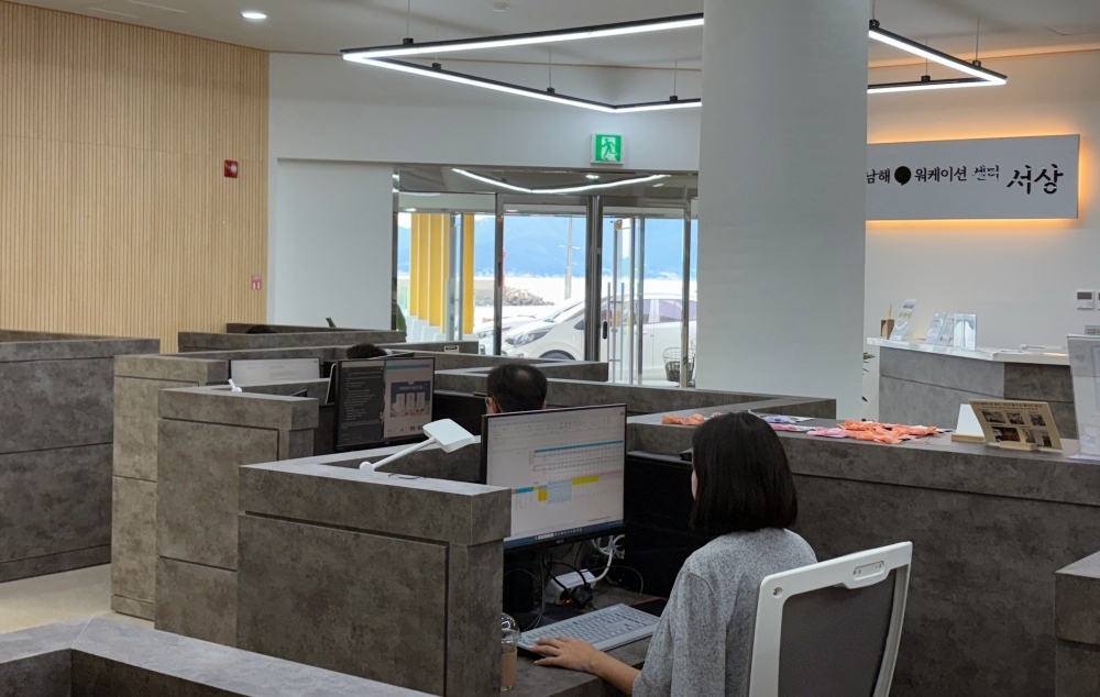 Workers on Sept. 19 type on their PCs at Seosang Workation Center in the township of Seo-myeon in Namhae-gun County, Gyeongsangbuk-do Province. Formerly a passenger ship terminal until the 2012 World Expo in Yeosu, Jeollanam-do Province, the facility underwent renovation and was reopened as a communal office space in April last year. (Charles Audouin)