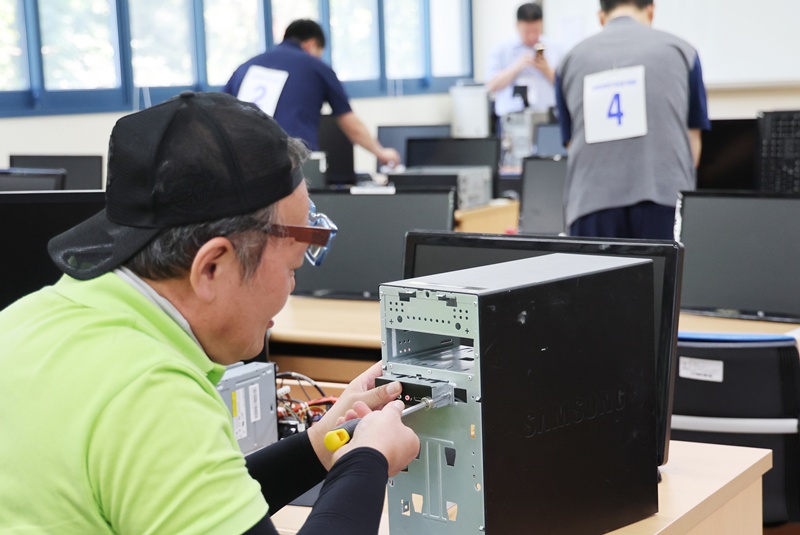  Competitors on May 26 in Busan fix computers in a skills contest for disabled people. (Yonhap News)